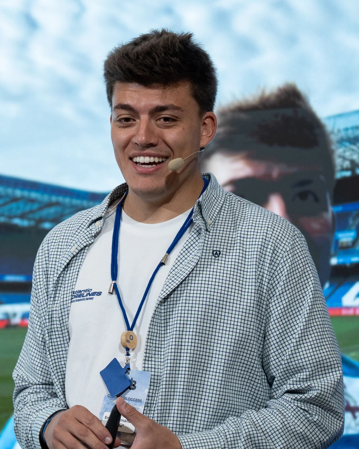 Emilio dando una charla, sonriendo, con micrófono de diadema
